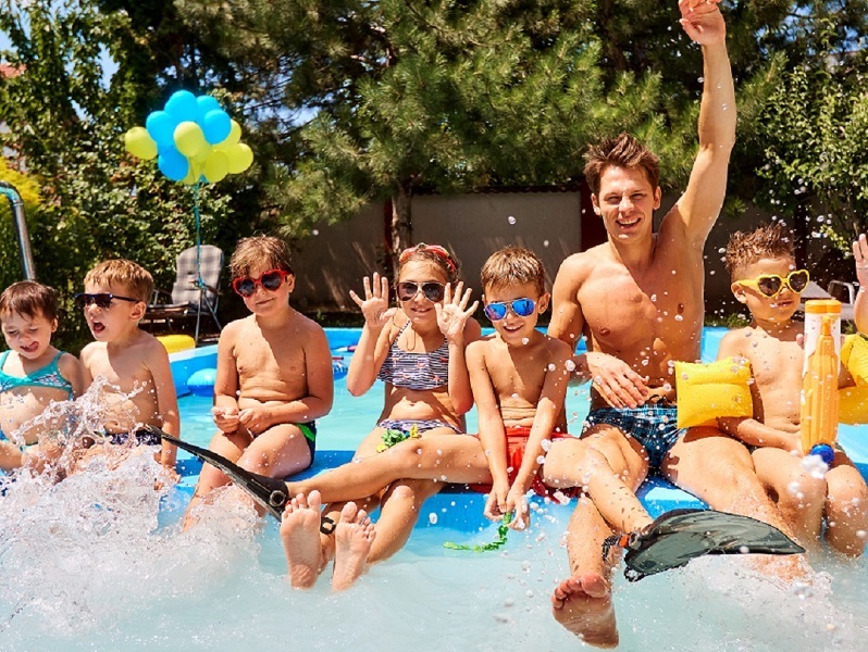 Children with a educator in pool in the summer camp.